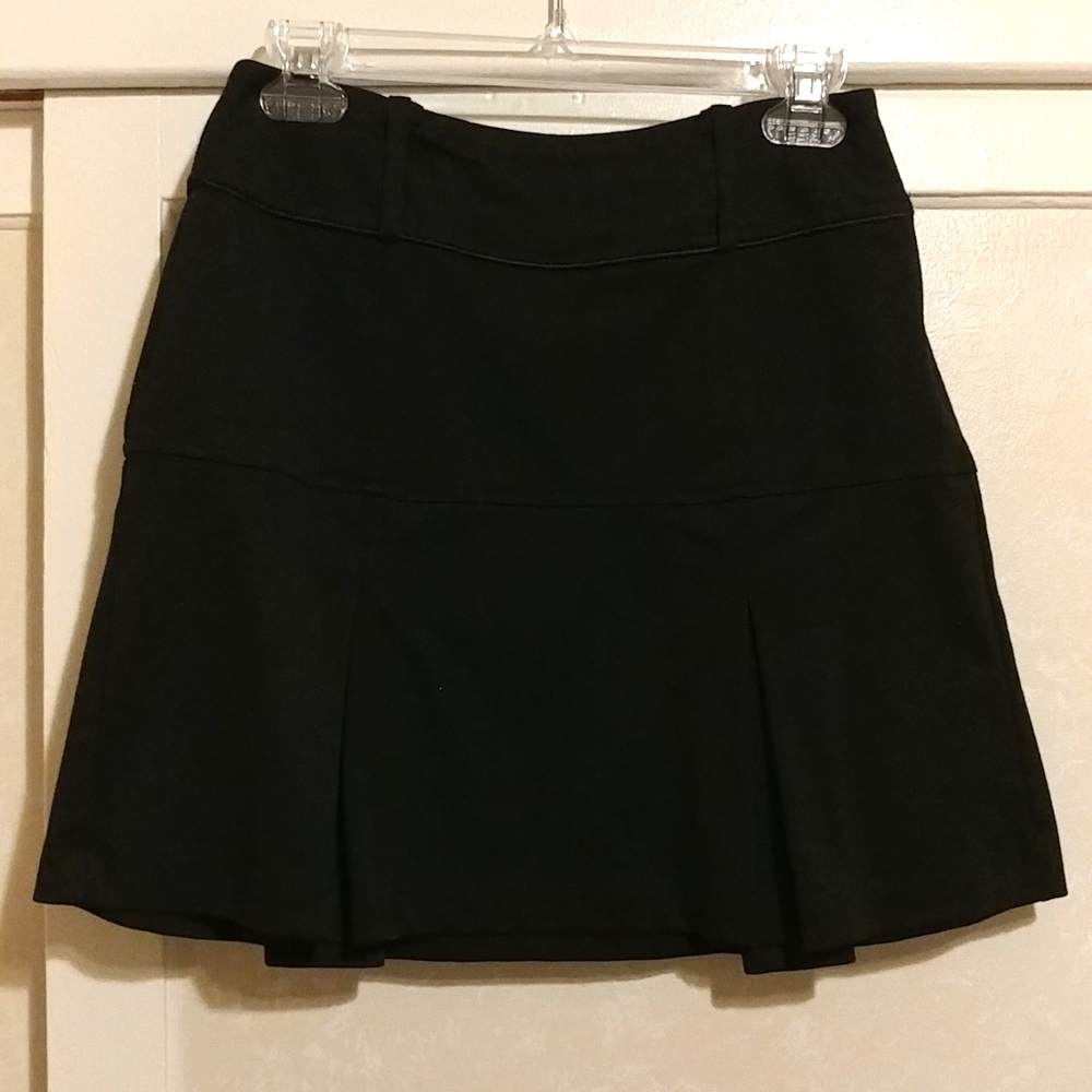 Black wide pleated mini skirts.
